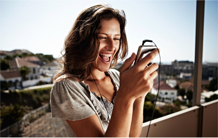 Eine junge Frau schaut aufs Hanhdy.