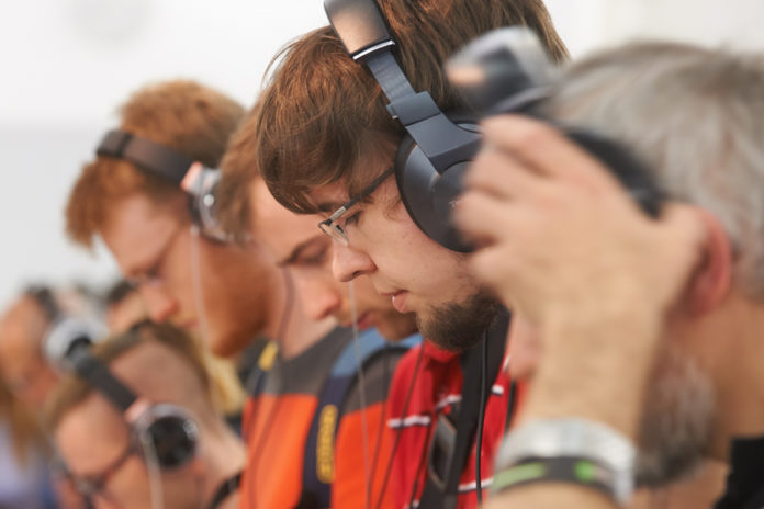 Personen mit Kopfhörer, die konzentriert Musik hören.